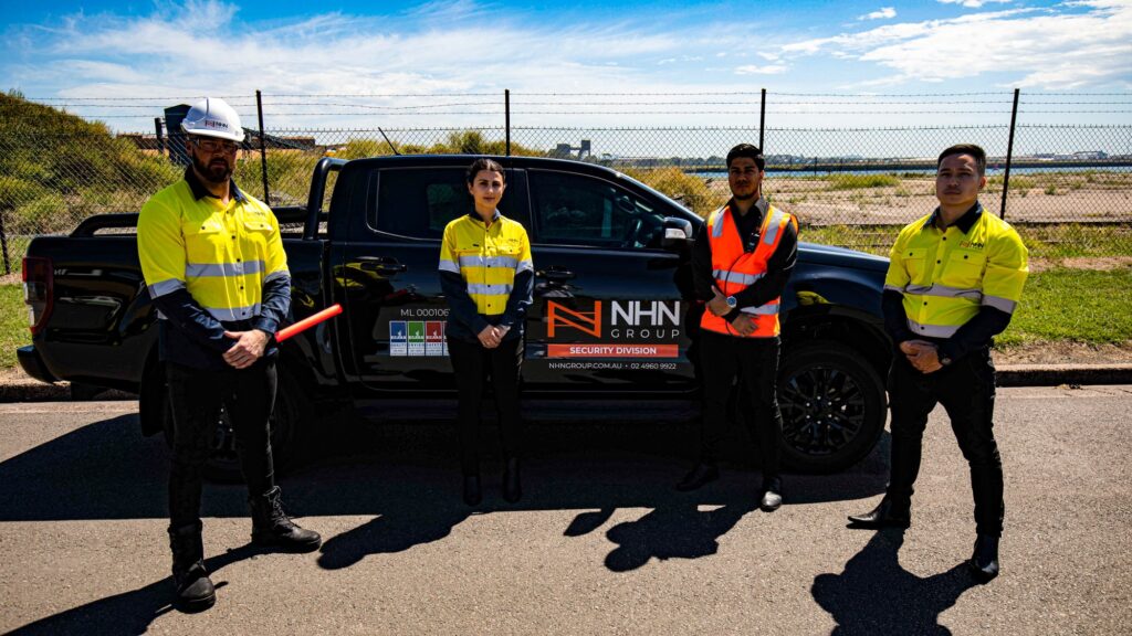 Four workers in high-vis in front of an NHN vehicle