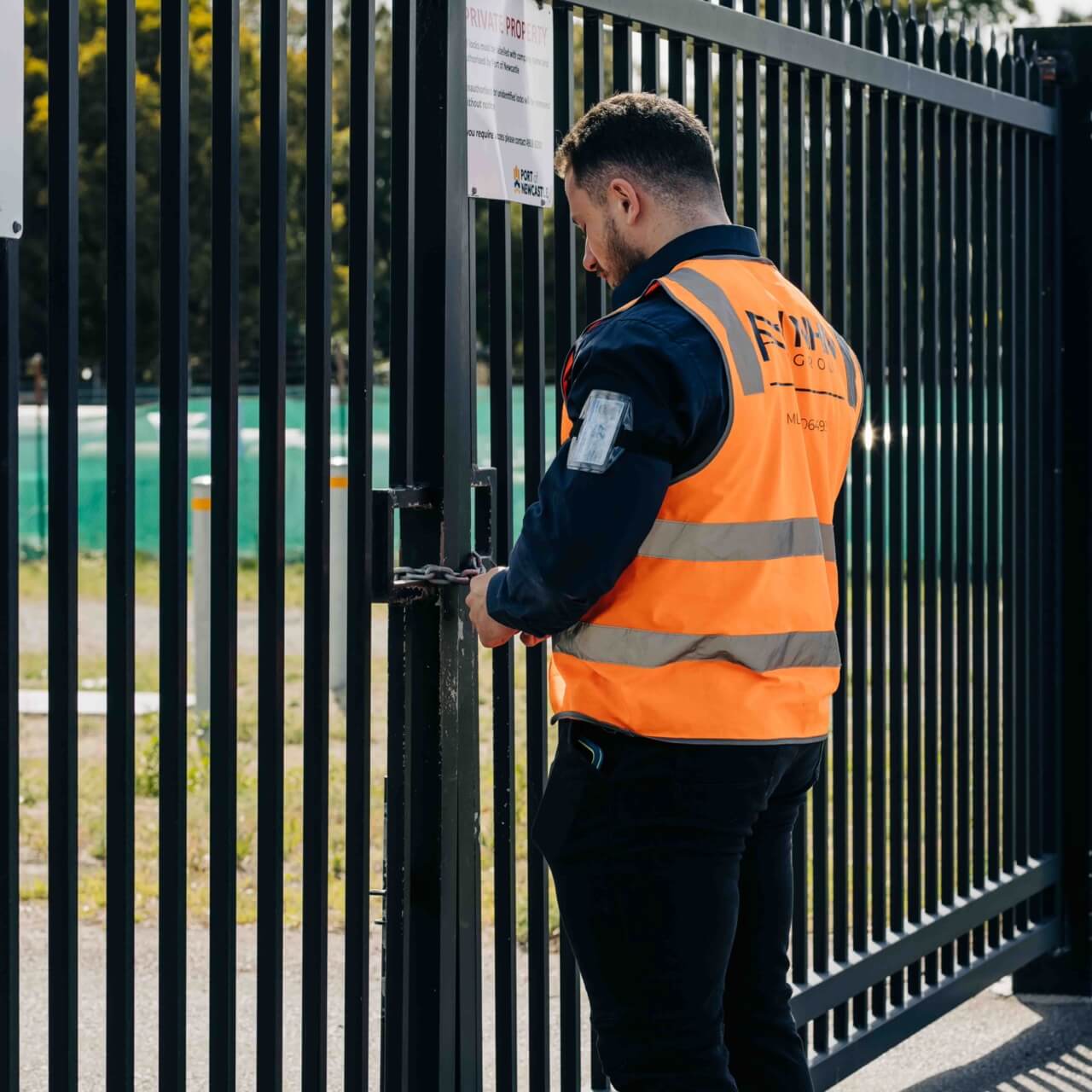Security guard locking a gate
