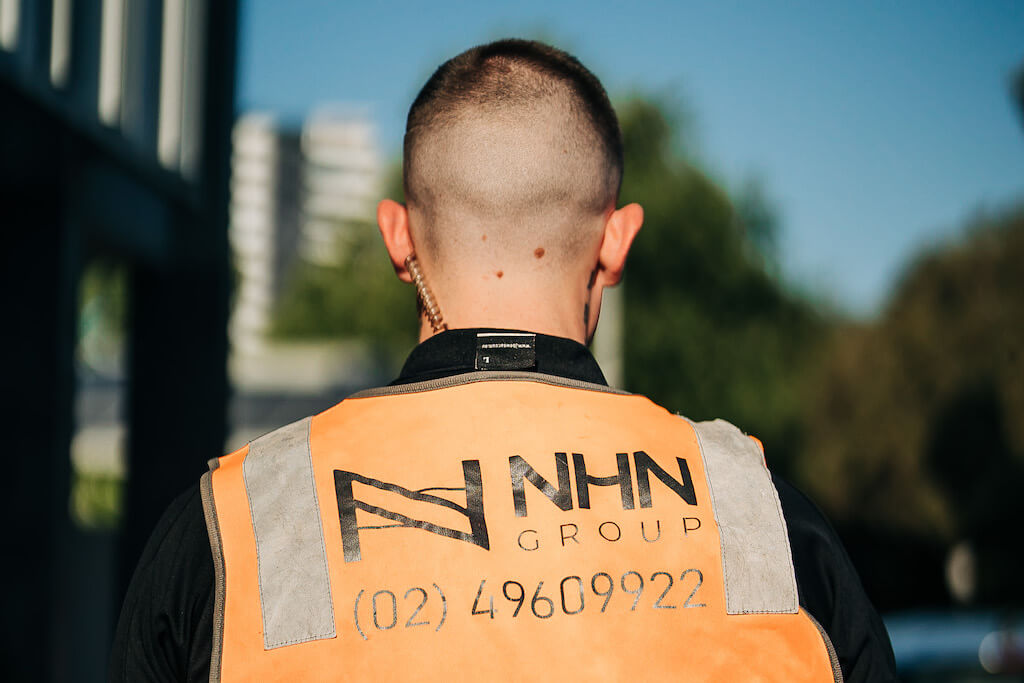 Close up of an NHN employee wearing a hi-vis jacket and earpiece